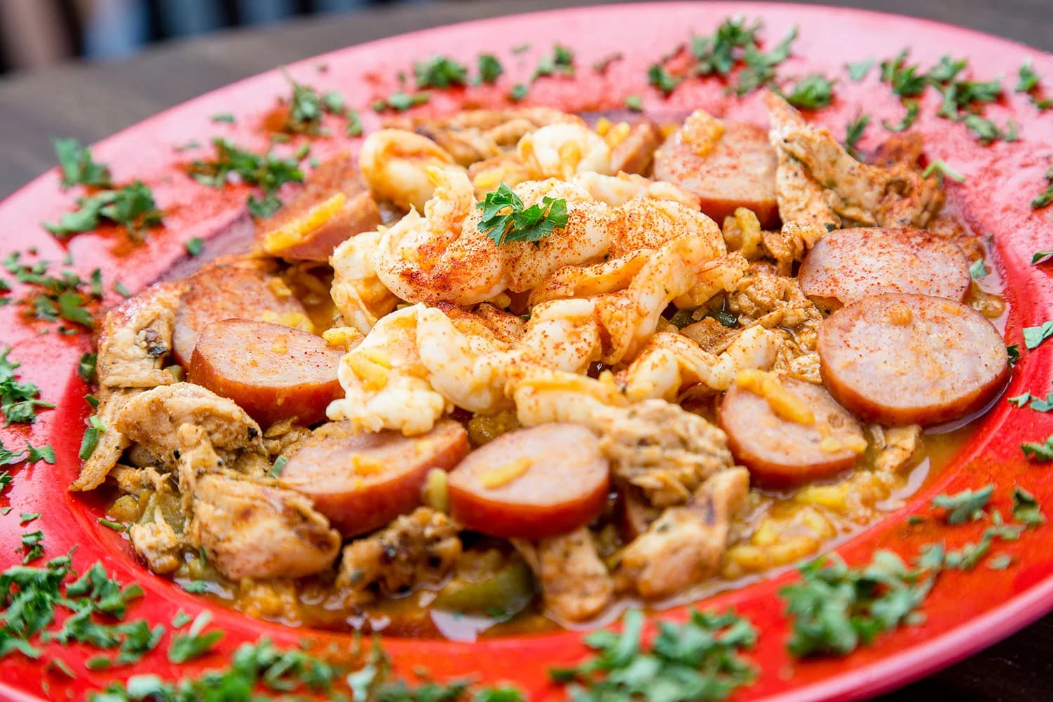 Jambalaya with shrimp, smoked sausage and chicken on a red plate