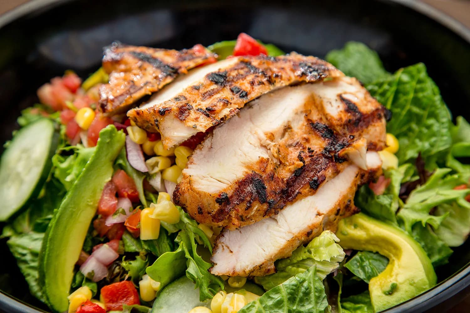 Yucatan salad topped with grilled chile-lime chicken, corn and avocado